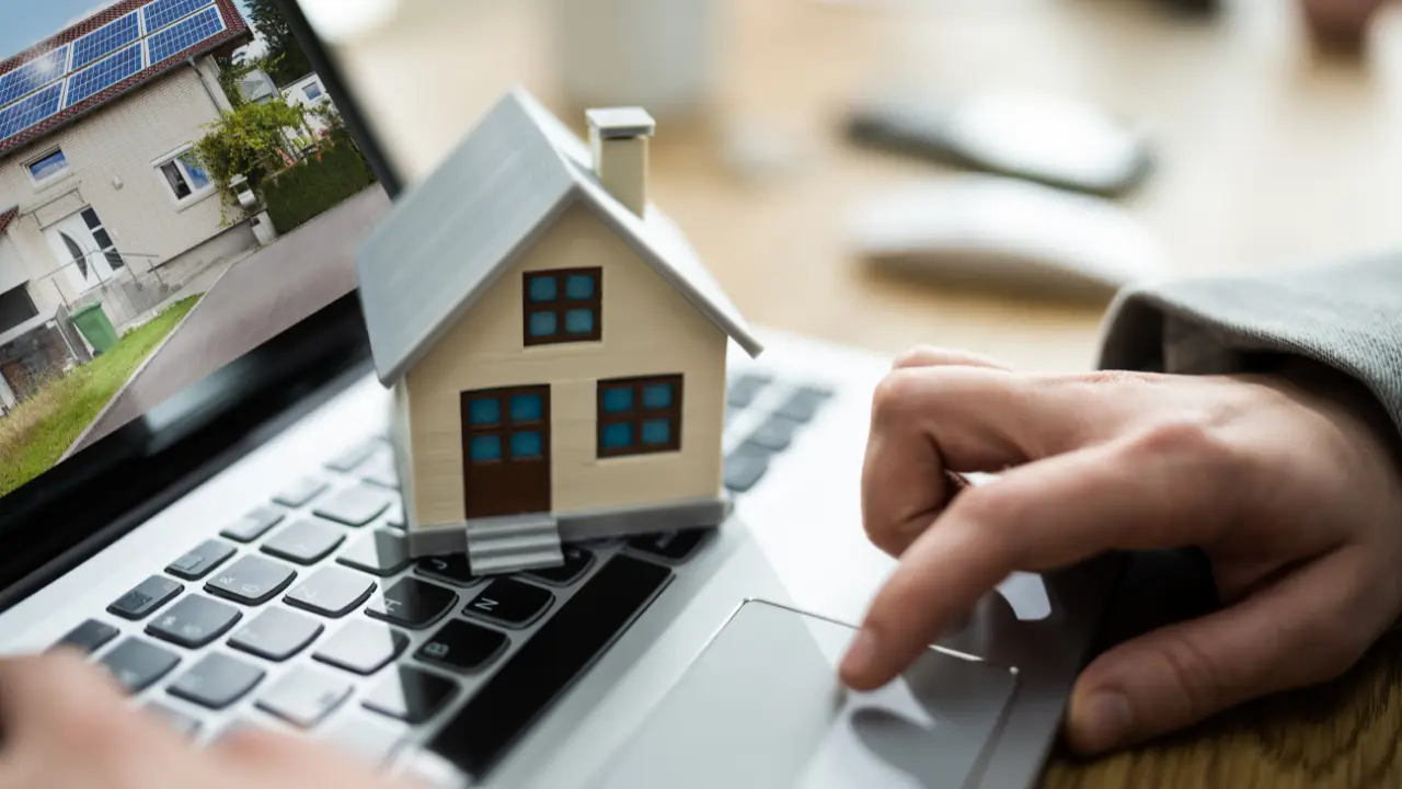 Photo d'un ordinateur et d'une maison individuelle illustrant Scoplan Logiciel Immobilier