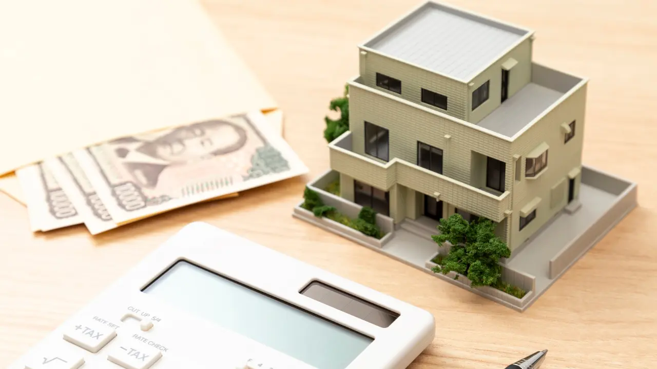 image d'une calculatrice et d'une maison représentant le calcul du prix d'un terrain et d'une maison