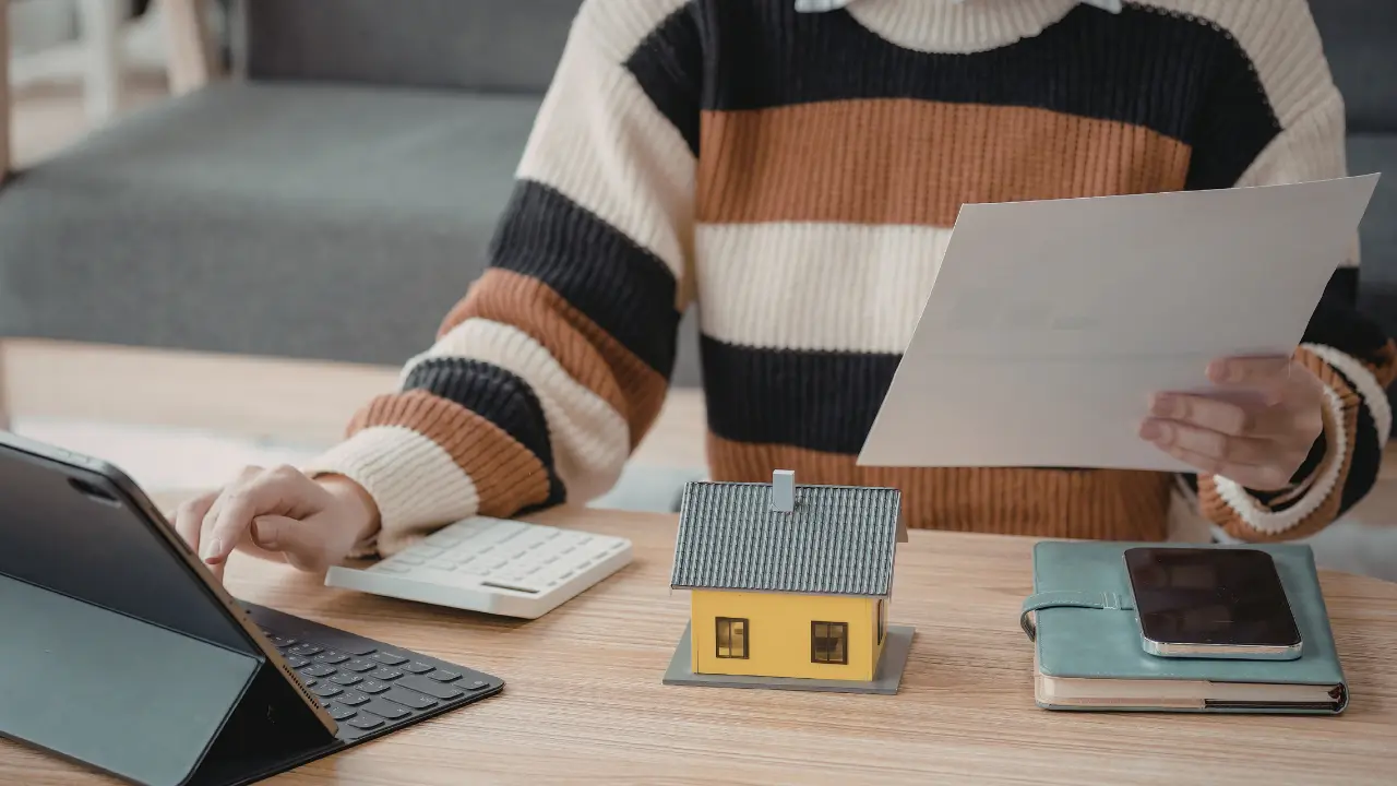 Calcul du coût division parcellaire : personne avec calculatrice et documents analysant le budget immobilier
