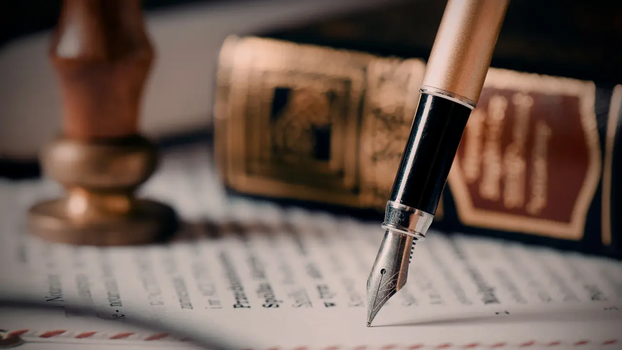 Signature d’un acte notarié : plume et sceau de notaire sur un document officiel, illustrant le calcul des frais de notaire lors de l’achat d’un terrain en 2026.