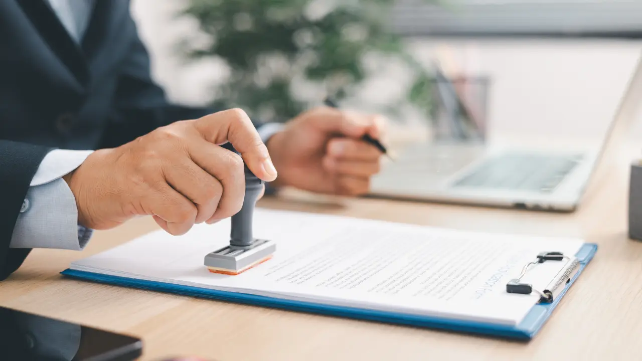 Permis d'aménager : agent administratif tamponnant un dossier d'autorisation d'urbanisme en mairie